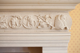 closeup corner of a highly detailed hand carved stone fireplace