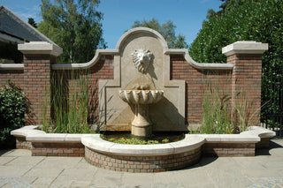 outdoor stone fountain with lion head detailing