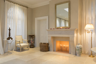 Candlelit room with stone hand carved fireplace and marble floors