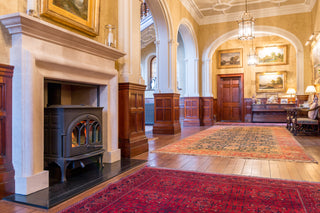 luxurious hallway in a stately home with hardwood floors and a fireplace and wood burner