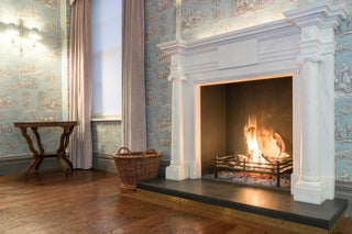 Luxurious room with a white marble fireplace, blue wallpaper, and hardwood floors